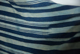 Faded indigo blue stripes with hand-woven texture on vintage African cotton textile.