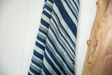 Folded collectible African indigo textile, displaying hand woven blue stripes and subtle stitched character.