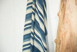 Hand woven African indigo textile showing varied blue and cream striped texture.