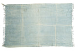 Hand-woven vintage African indigo textile, with varying denim blue tones and soft fringe.