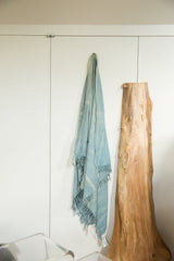 Draped vintage denim indigo African textile throw with hand-woven texture and fringe.