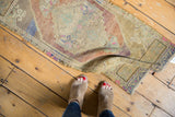 Vintage distressed Oushak runner showing soft pile with interwoven vinery and abrashes.