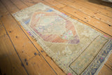 Distressed vintage Oushak rug with stepped medallion, floral vinery, and pale copper, blue tones.