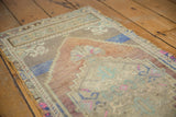 Textural distressed pile and stepped contour of a vintage Oushak rug in pale hues.