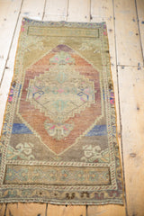 Lower corner detail of the distressed Oushak rug, showing low pile and geometric border.
