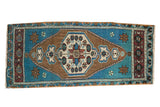 Distressed Oushak rug runner with aqua blue field, bronze brown medallion, and floral motifs.