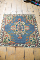 Distressed vintage Oushak rug's bottom border with sky blue, beige, terracotta floral motifs.