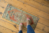 Faded terracotta and pale green distressed Oushak rug mat with low pile.