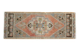Distressed vintage Oushak runner with rose, ivory, and silver geometric medallion and palmette ends.