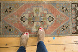 Vintage distressed Oushak rug runner with geometric medallion, palmette motifs, dusty rose, and ivory.