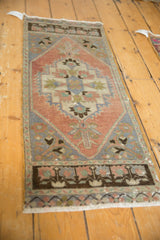 Distressed vintage Oushak rug showing geometric medallion, dusty rose, and oxidized silver tones.