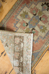 Folded vintage distressed Oushak rug fringe and worn pile, revealing its hand-knotted foundation.