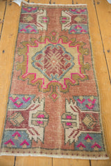 Vintage distressed Oushak rug center medallion with fuchsia, slate blue, and ivory plant motifs.