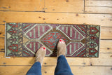 Distressed vintage Oushak runner's geometric medallion, in red, mint, and aubergine.