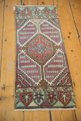 Distressed Oushak rug detail: worn aubergine pile, geometric motifs in brick, mint.