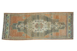 Distressed vintage Oushak runner with elongated medallion in pale apricot, silver, sky blue, and mauve tones.