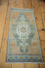 Corner detail of a distressed vintage Oushak runner, with time-softened apricot and blue tones.