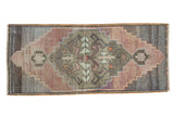 Distressed Oushak runner with a stepped geometric medallion in muted mauve, silver, and aubergine.