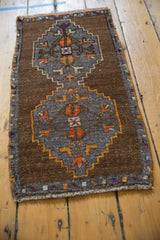 Distressed Oushak rug with interconnected bronze and grey serrated medallions and tangerine patterns.