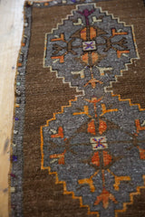 Distressed low pile and geometric floral motifs in coffee brown and tangerine orange.