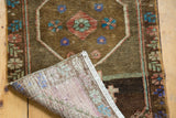 Detail of vintage distressed Oushak rug pile, visible foundation, and simple white fringe.