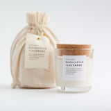 Eucalyptus Lavender soy candle in a clear glass jar with cork lid and fabric gift bag.