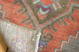 Distressed Oushak rug showing its brick red pile, even wear, and woven reverse.