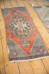 Distressed Oushak runner corner, showing brick red field, oxidized silver, and floral motif.