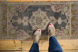 Vintage distressed Oushak rug showing ornate central medallion and faded floral patterns.