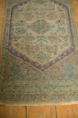 Distressed Oushak rug texture with visible knot heads, pale mauve, and muted teal details.