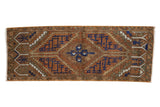 Distressed Oushak rug with a central geometric medallion in chestnut, navy blue, and ivory tones.