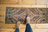 Distressed Oushak runner, chestnut brown and navy serrated center medallion.