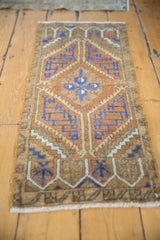 Distressed vintage Oushak rug's geometric pattern, worn pile, and end fringe.