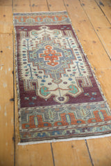 Distressed texture of vintage Oushak rug's geometric and floral details in aubergine, ivory, rust.