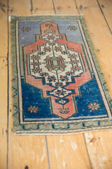 Distressed lower corner of vintage Turkish Oushak rug, showing royal blue and terracotta motifs.