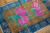 Distressed copper bronze field with bright pink rose floral, green leaves, and sapphire blue border.
