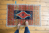 Distressed vintage Oushak rug with stepped medallion, cherry red, dark navy, and antique ivory.