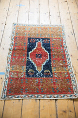 Distressed vintage Oushak rug, central stepped navy blue medallion, cherry red field, even wear.