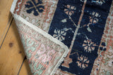 Distressed vintage Oushak rug foundation and fringe, revealing pale tones and navy pile.