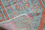 Distressed Oushak rug showing worn pile, vibrant pink, orange, and hand-knotted reverse.