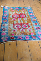 Distressed lower corner of vintage Oushak rug, showing pink and green geometric florals.