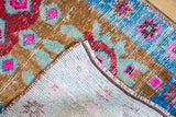 Hand knotted Oushak rug pile with worn texture, visible foundation, and secured edge.