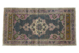 Distressed vintage Oushak rug, ornate floral medallion in oxidized silver, mauve, ivory, and bronze.