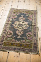 Distressed vintage Oushak rug detail with mauve pinwheel spandrel on oxidized silver.