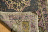 Hand knotted vintage Oushak rug, showcasing secured edge, woven foundation, and time-softened mauve pile.