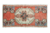 Distressed vintage Oushak rug mat: serrated medallion, brick red, ivory, slate blue hues. 1'7