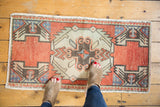 Distressed vintage Oushak rug mat, showing ivory serrated medallion and brick red field.