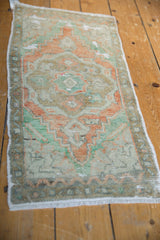 Terracotta, mint green, and ivory hues on a distressed vintage Oushak rug pile.