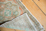 Vintage Oushak rug's lifted corner revealing secured edge, worn pile, and foundation.