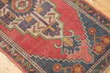Distressed Oushak rug: black cherry red field, dark navy charcoal teal zigzag border.